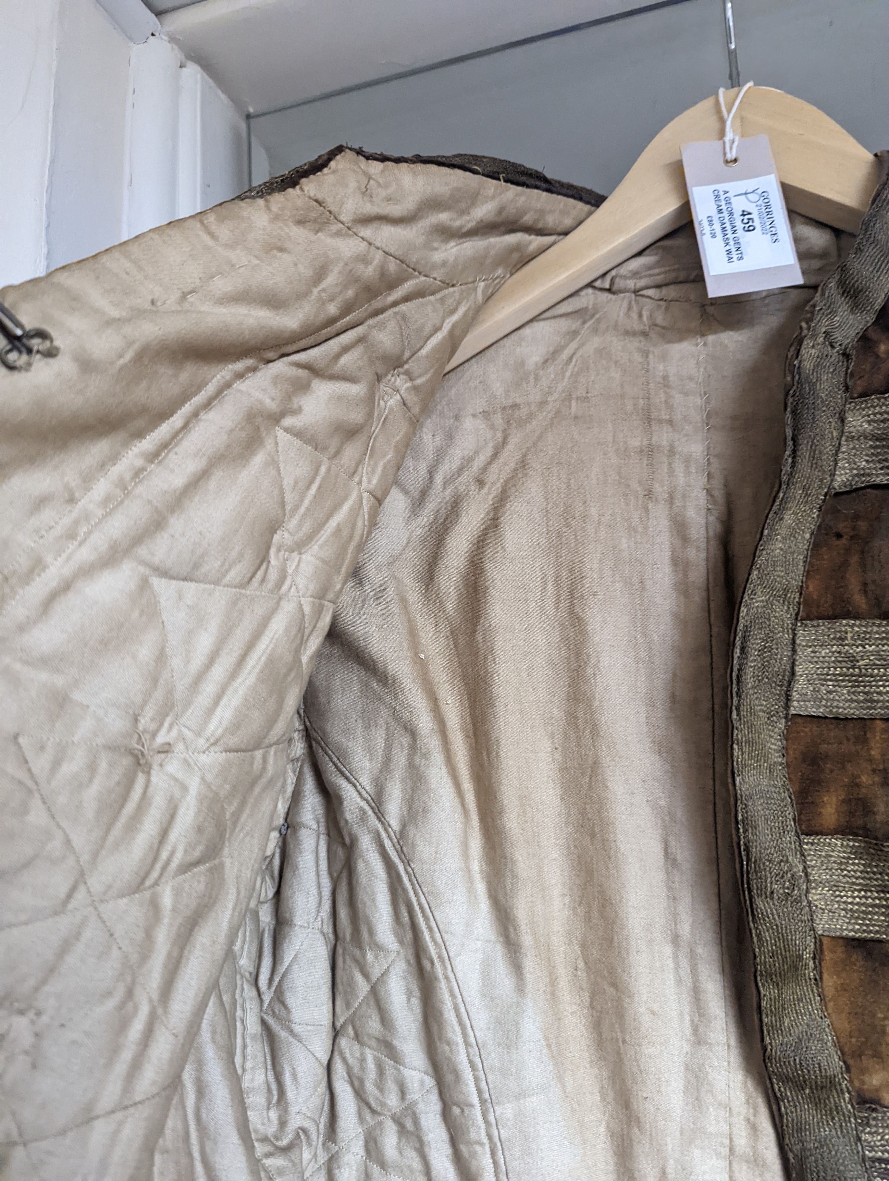 A Georgian gents cream damask waistcoat, a similar waistcoat with beading applied later and a velvet and gold braided tailcoat